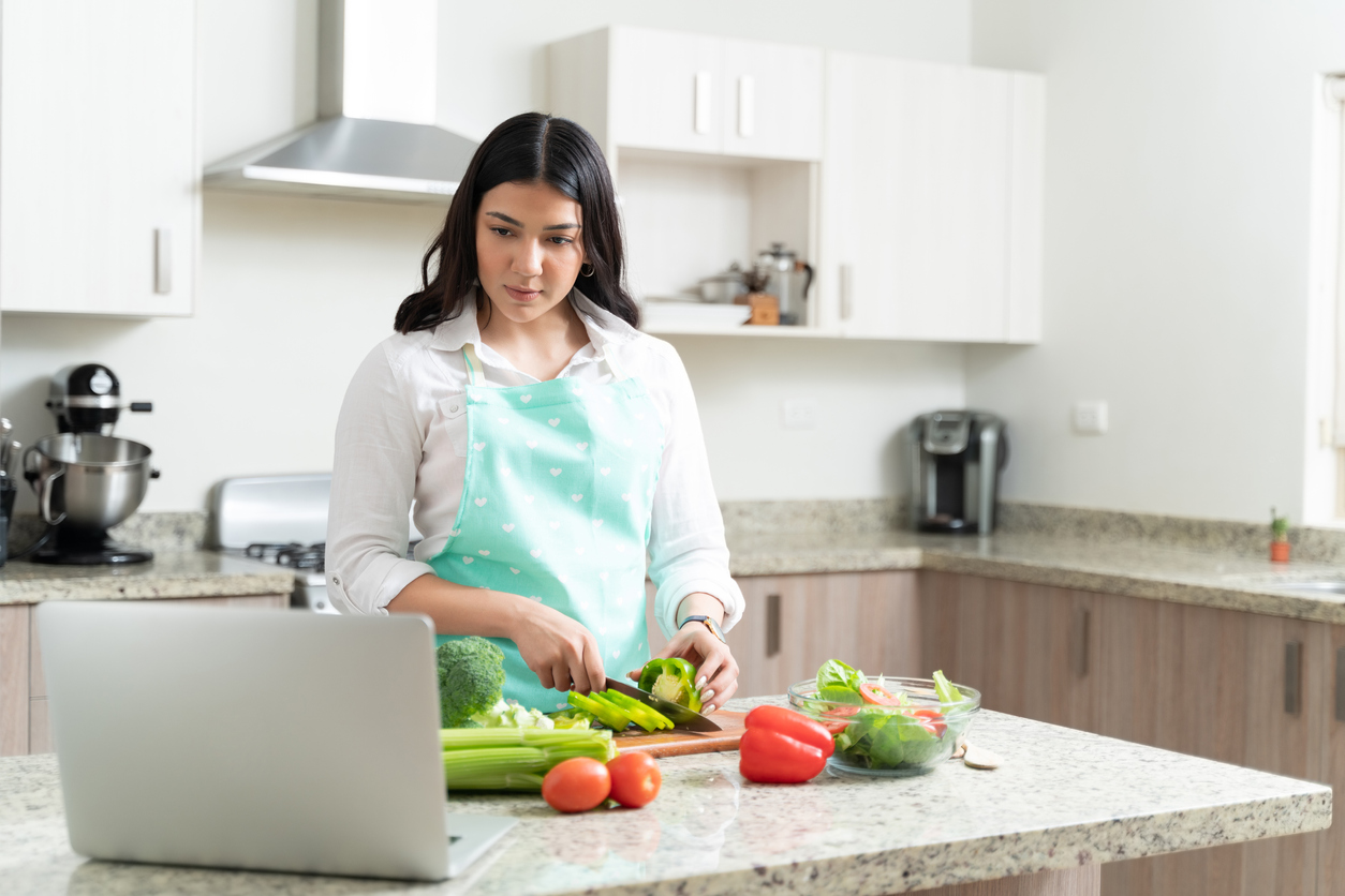 Young Gorgeous Woman Preparing Vegetable Salad In Kitchen